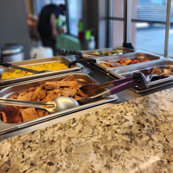 ChuMinh Tofu's buffet line with various Vietnamese dishes, including tofu and yellow rice.