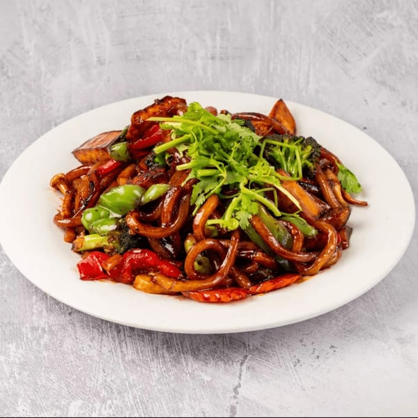 ChuMinh Tofu's stir-fried noodles with vegetables and dark sauce, garnished with fresh cilantro.